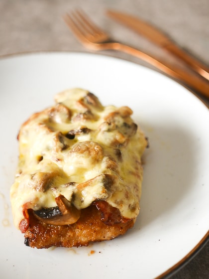 Schnitzel met champignons, ui, spek en gesmolten kaas | Foodaholic.nl